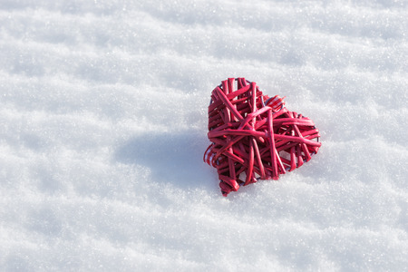 Red heart in the fresh white snowの写真素材