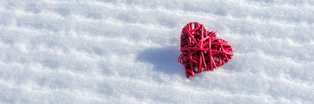 Red heart in the fresh white snowの写真素材