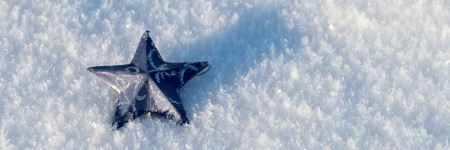 Blue star in the snow. Winter snow background