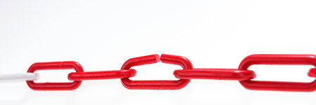 Red chain with broken element on white backgroundの写真素材