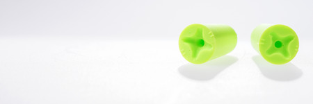 Two green ear plugs isolated on white background