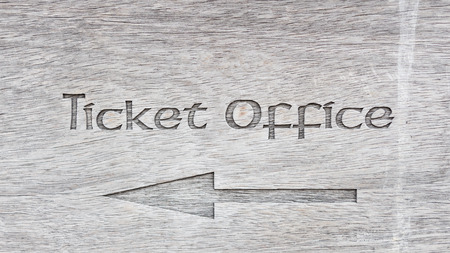 Text ticket office with arrow on wooden panel