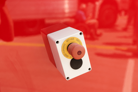 Emergency button on red background, german Not-Aus