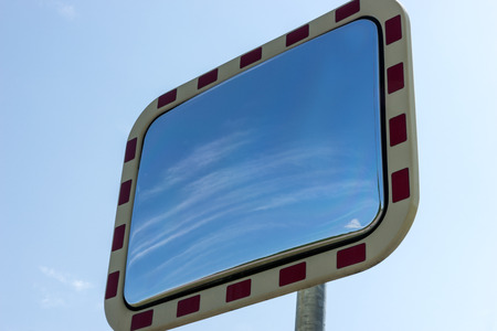 Rectangular road mirror with clouds in the mirror