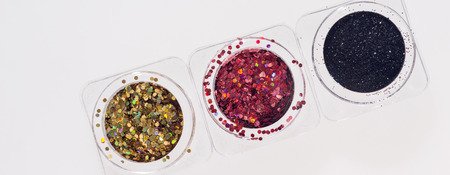 Black, red and golden glitters in transparent jars