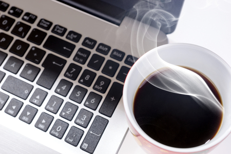 Top view of an office table. Laptop computer with cup of black coffeeの写真素材