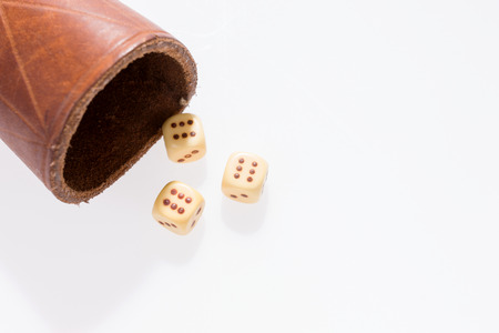 Three dice with leather cup on white backgroundの写真素材