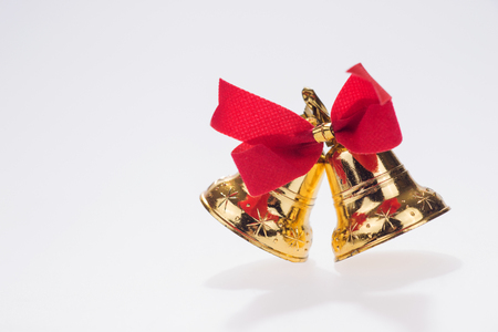 Pair of golden bells with red bow isolatedの写真素材