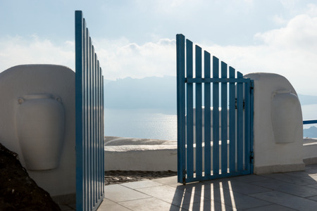 Open blue door overlooking the Mediterranean sea in Santoriniの写真素材