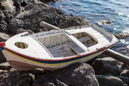 Old wooden boat beached at the seaside in Oia, Santoriniの写真素材