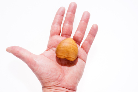 Man holds wooden heart in the left handの写真素材