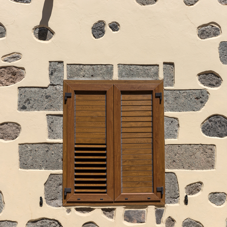 Part of the wall of the house with a wooden windowの写真素材