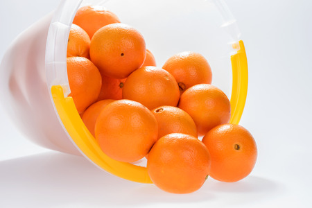 Many fresh oranges in the plastic bucketの写真素材