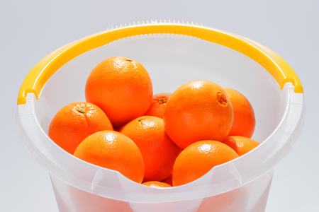 Many fresh oranges in the plastic bucketの写真素材