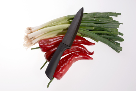 Paprika, bunch of spring onions and black knife isolatedの写真素材