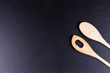 Black slate board for two wooden spoons, top viewの写真素材