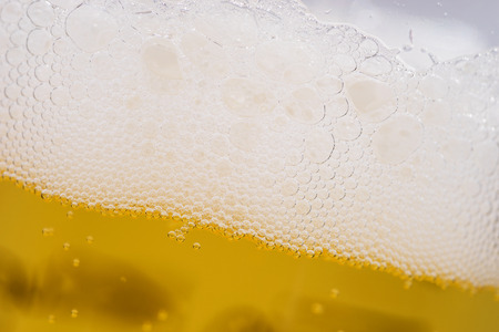 Close up of beer bubbles with froth, beer background