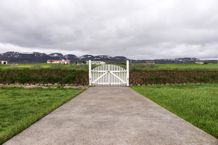 Closed white wooden gate with mountains in the backgroundの写真素材