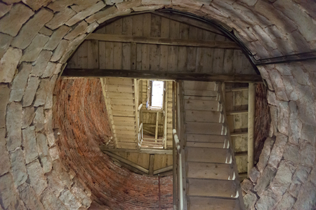 Wooden staircase in a round stone towerの写真素材