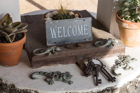Metal sign Welcome on the old well with a wooden lidの写真素材