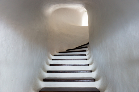Stairway with dark wooden steps in the light tunnelの写真素材