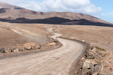 Dry dusty road leads into the mountainsの写真素材