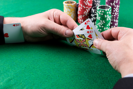 Man with red ace up his sleeve. Cheating at poker
