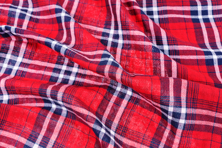 Wrinkled material. Red dark blue checked shirt cloth background