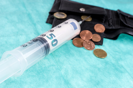 Syringe with fifty euro bill in the black leather walletの写真素材
