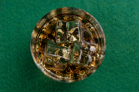 Glass of whiskey  on the green poker tableの写真素材