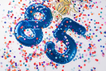 Blue number 85 with colorful confetti. 85th birthday anniversary greeting logoの写真素材