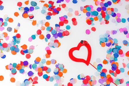 Colorful confetti with red heart on white backgroundの写真素材