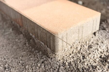 New paving slabs along a directional cord on a prepared flat surfaceの写真素材