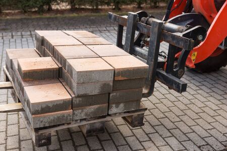 Forklift with new paving stones on the wooden pallet