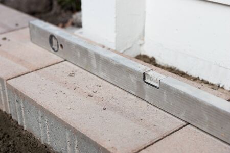 Construction level ruler on the new paving slabs. Construction work