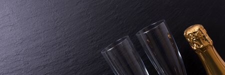 Panoramic image. Champagne bottle on black slate plate. Copyspaceの写真素材