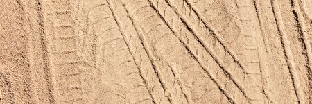 Panoramic image. Tire tracks on the sand. Sand texture