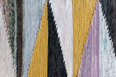 Texture of old woven fabric from fragments of different colors