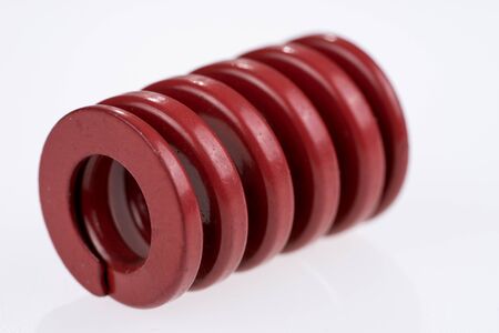 Red strong metal spring isolated on a white backgroundの写真素材