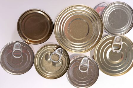 Various canned food in metal cans, top view. Canned goods non perishable food storage goods
