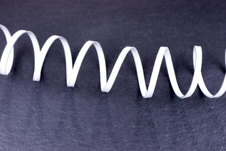 Bright metal spiral on dark background. Metallic circular spiral patternの写真素材