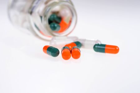 Heap of colorful pills from a glass tube. Isolated. Copy spaceの写真素材