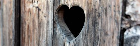 Heart shape at an old wooden door of a toilet. Panoramic imageの写真素材