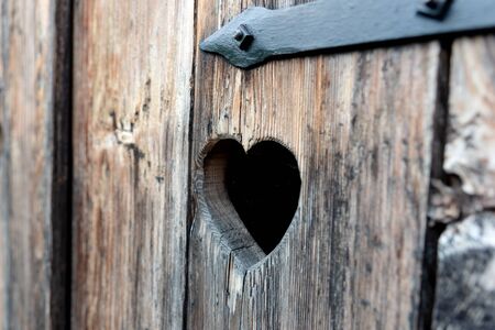 Heart shape at an old wooden door of a toiletの写真素材