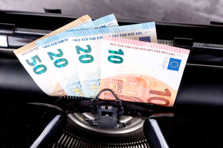 Vintage typewriter printing Euro bills, make money concept