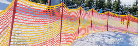 Colorful plastic fence on the ski slope in winter. Panoramic imageの写真素材