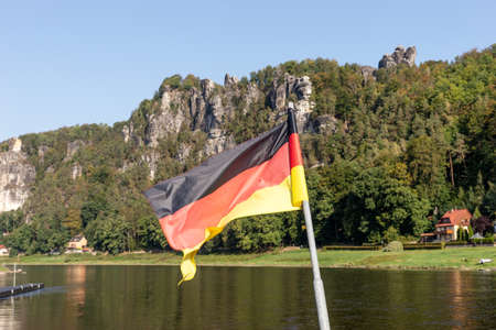 Waving National Flag of Germany and mountains in Saxon Switzerland. Germanyの写真素材
