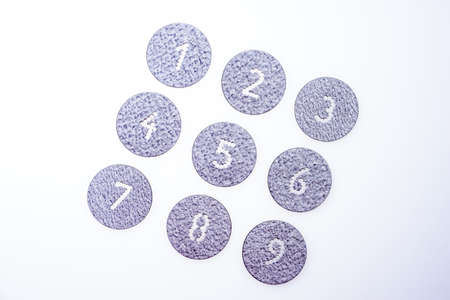 Set of numbers from 1 to 9 punched into round silver metal platesの写真素材