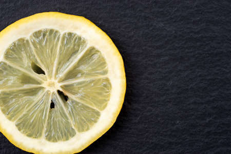 Top view of sliced yellow lemon on black backgroundの写真素材