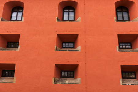 Orange facade with small windows. Architectural backgroundの写真素材